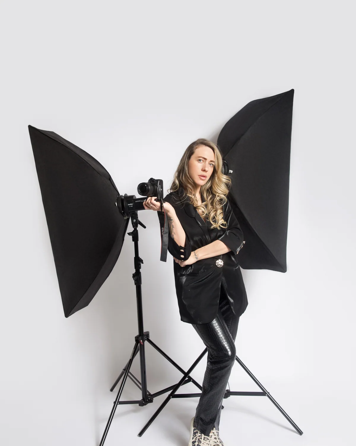 Romina Rau in ihrem Studio in Gießen, in Schwarz gekleidet mit ihrer Kamera.