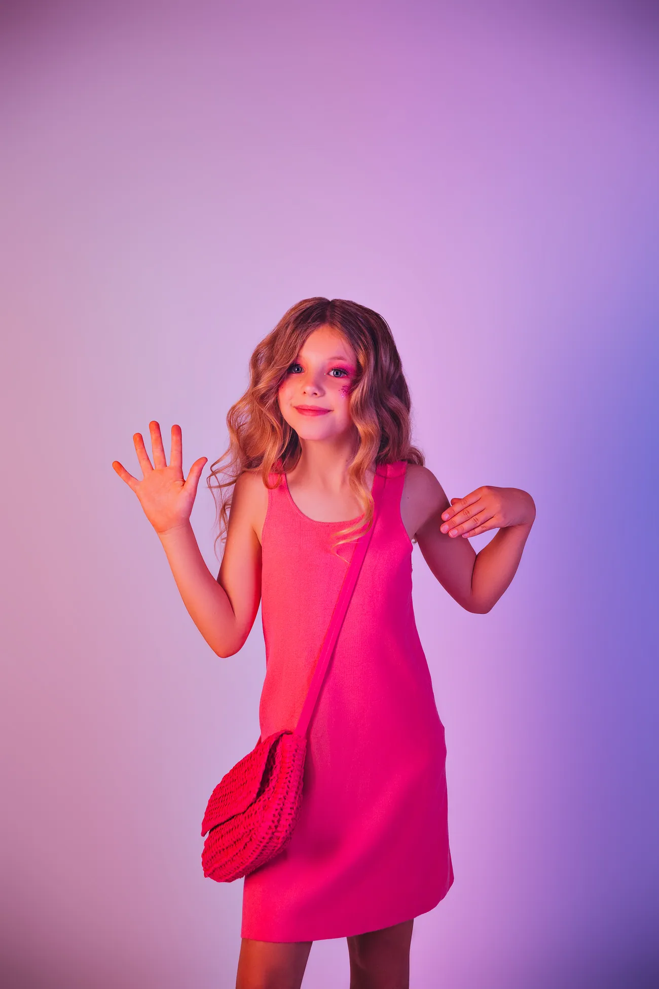 Mädchen in einem pinkfarbenen Kleid vor lila Hintergrund, farbenfrohes Portrait.