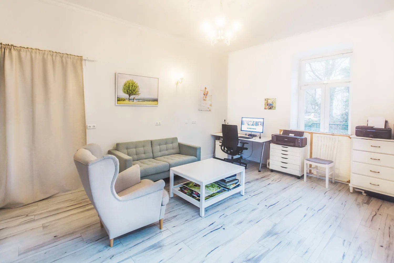 Gemütlicher Wartebereich im Studio mit hellem Sofa und Sessel.